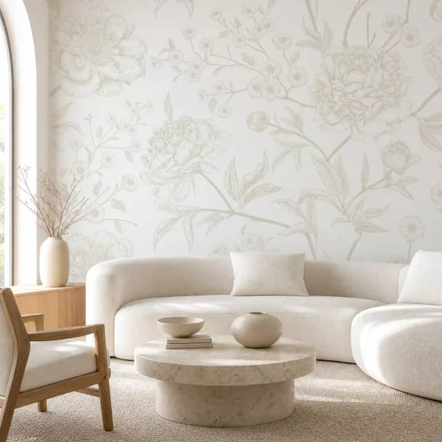 White botanical mural behind a curved cream sofa in a bright living room