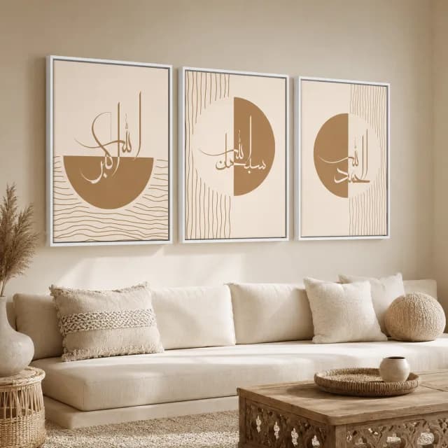 ثلاث لوحات إسلامية بإطارات بيضاء وخط ذهبي فوق أريكة بألوان حيادية.