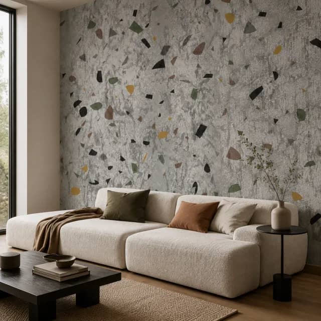 Grey terrazzo wallpaper mural behind a modern sofa in a living room