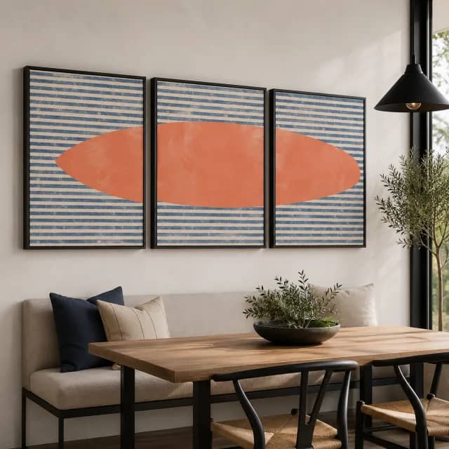 Coral Drift three-piece wall art in black frames above a modern dining nook