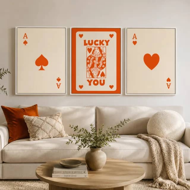 Orange playing card wall art in white frames above a light sofa