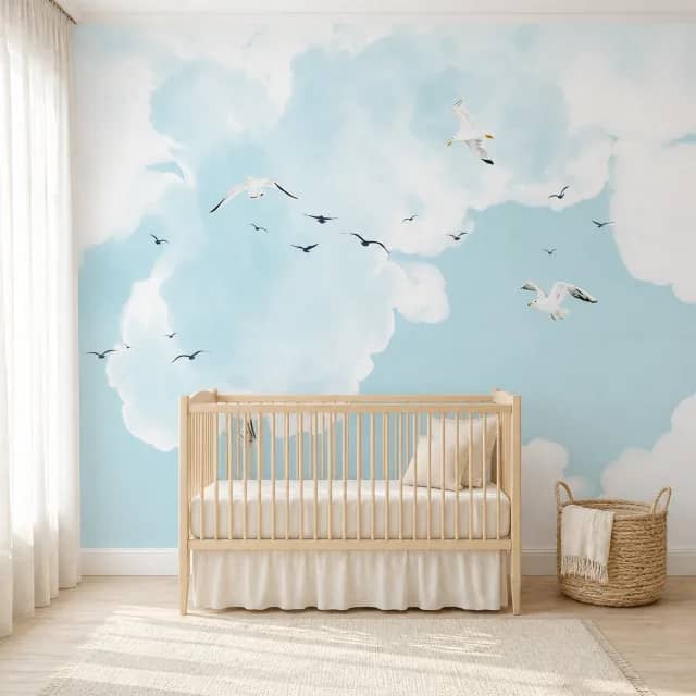 Seagull Sky wallpaper in a nursery with a natural wood crib