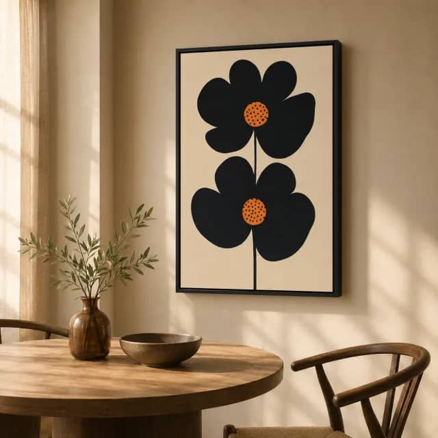 Black botanical artwork above a wood table in a warm dining space